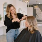 Stylist finishing a haircut and style at Halo Salon in Auburn, AL