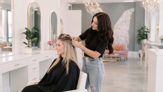 Stylist fitting hair extensions at Halo Salon in Auburn, AL