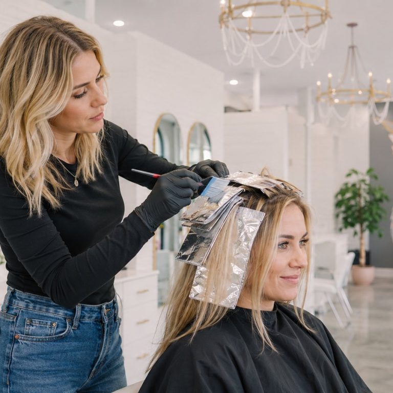 Colorist foiling highlights at Halo Salon in Auburn, AL